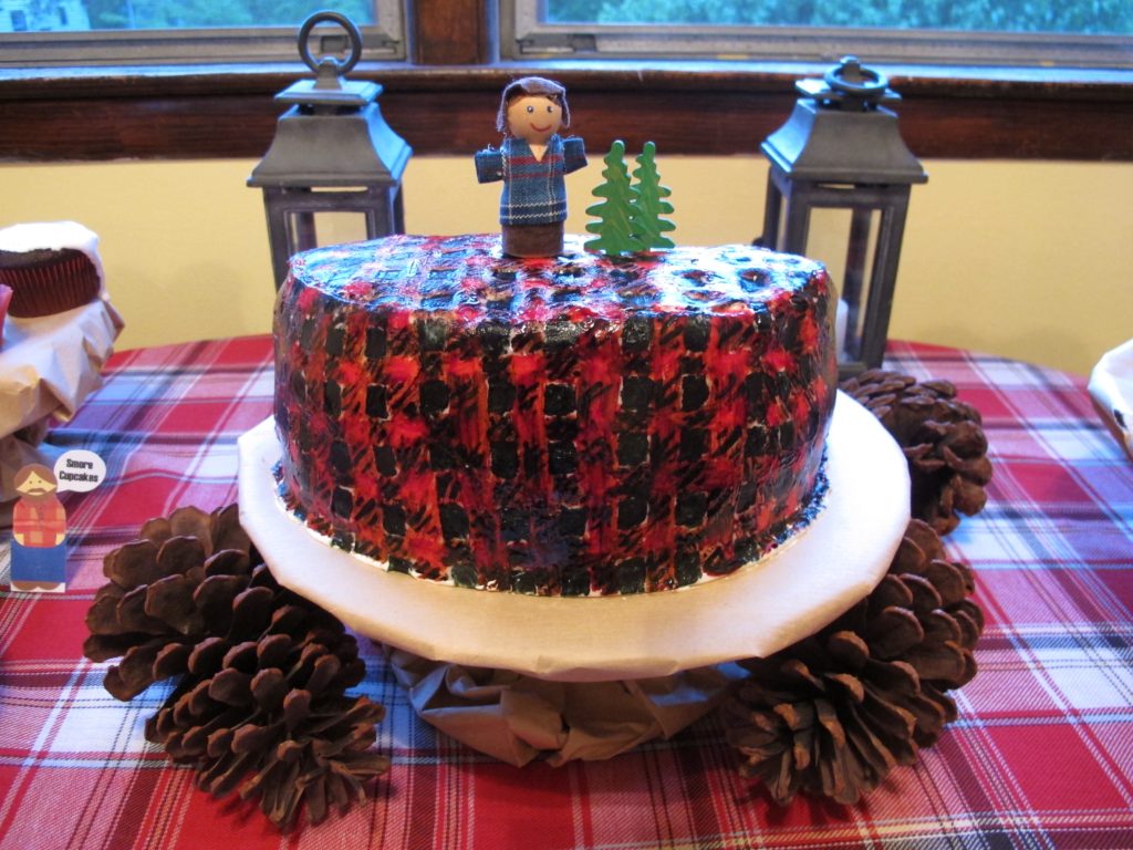 This plaid lumberjack cake was made with fondant and food coloring. A tiny lumberjack made from wood and scrap fabric along with two wooden trees sat atop the cake. I covered an ordinary cake stand in brown butcher paper to make it look like a tree stump.