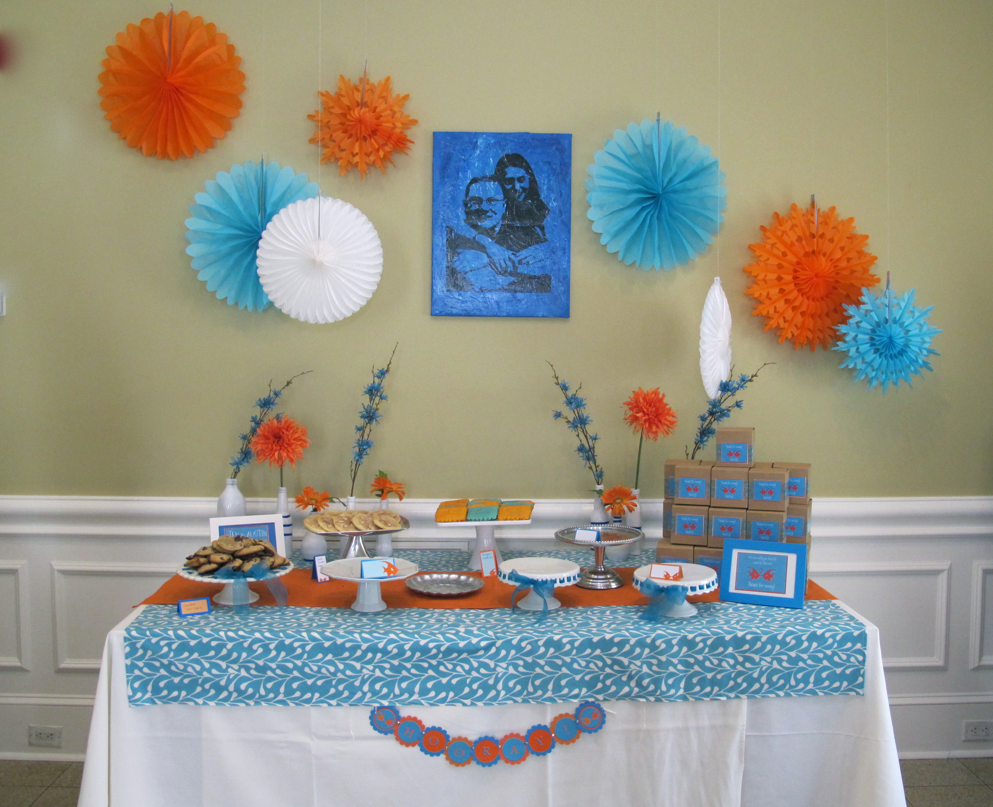 This party was a lot of fun to decorate for. The groom’s favorite color is orange (go Texas!) and so we used orange and blue as the main colors. The shower was at a beautiful restaurant, so the only thing we did was the dessert table and the guest’s tables. We collected glass vases and jars and spray painted them all white, then added blue artists tape to give them some fun lines. Orange and blue flowers were picked up at a local craft store and added to the vases, which sat behind the dessert table.