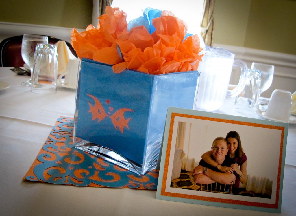 we made 'fish bowls' for each table using blue paper and tiny fish cut-outs in glass vases. Tissue paper flowers were put inside, and the pictures from the couples engagement session were displayed on tables around the room.