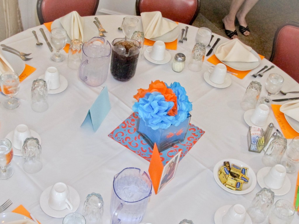 we made 'fish bowls' for each table using blue paper and tiny fish cut-outs in glass vases. Tissue paper flowers were put inside, and the pictures from the couples engagement session were displayed on tables around the room.