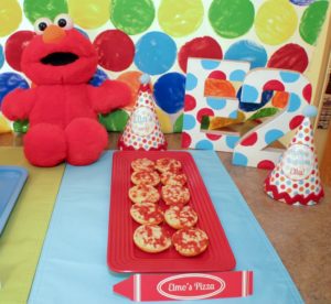 Elmo Party Decorations | We turned an ordinary kitchen island into a colorful party table by making this polka-dot backdrop. Add in balloons, festive table-wear, and lots of party food for a great ‘Elmo’s World’ kids party!